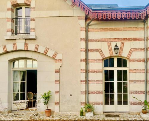 une maison blanche avec deux fenêtres et une porte dans l'établissement Maison Adrienne, à Saint-Aignan