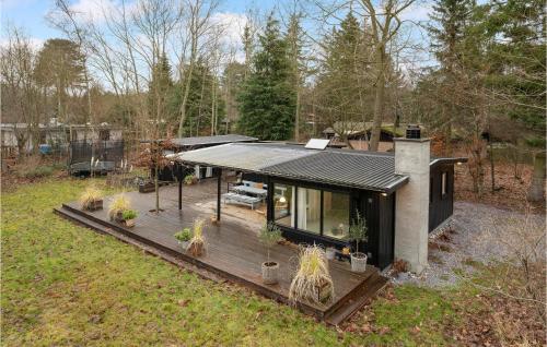 a house on a wooden deck with potted plants at Gorgeous Home In Strøby With Kitchen in Strøby