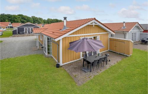 a house with a table and an umbrella in the yard at Beautiful Home In Gråsten With Kitchen in Gråsten