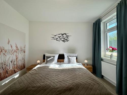 ein Schlafzimmer mit einem großen Bett und einem Fenster in der Unterkunft Haus Concordia 2 Möwennest in Thiessow