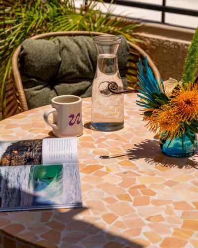 a table with a bottle of water and a coffee cup at Wayfinder Waikiki - Voted Top 10 Best Hotels in Hawaii! in Honolulu