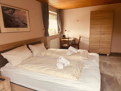 a bedroom with a white bed with pillows on it at Hotel-Restaurant Olympia in Selm