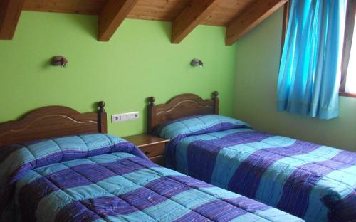2 camas en un dormitorio con paredes verdes en Casa La Bordeta Remondillo, en San Juan de Plan