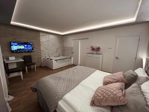 a bedroom with a large bed and a tv at S class apartment in Novi Grad