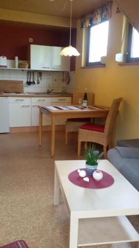 a living room with a table and a kitchen at Wohnung mit Balkon und Blick auf die Weinberge in Kröv