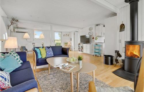 a living room with a couch and a table and a fireplace at Two-Bedroom Holiday Home In Borkop in Børkop