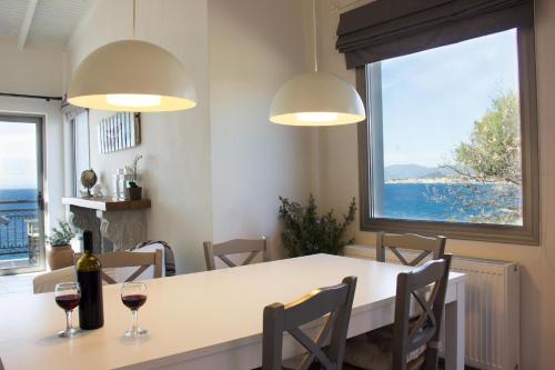 a dining room with a table and two glasses of wine at Mani Apartments in Agios Nikolaos