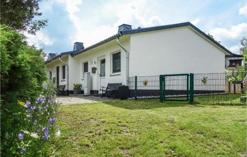 a white house with a fence in a yard at Lovely Home In Diemelsee Ot Sudeck in Rhenegge