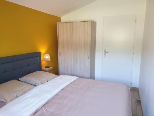 - une chambre avec un grand lit blanc et un placard dans l'établissement Gîte et piscine l'écrin aux oliviers en Cévennes, à Saint-Christol-lès-Alès