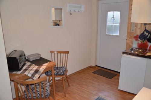 a small kitchen with a table and a small kitchen with a refrigerator at Ferienwohnung Krummhörn Upleward in Krummhörn