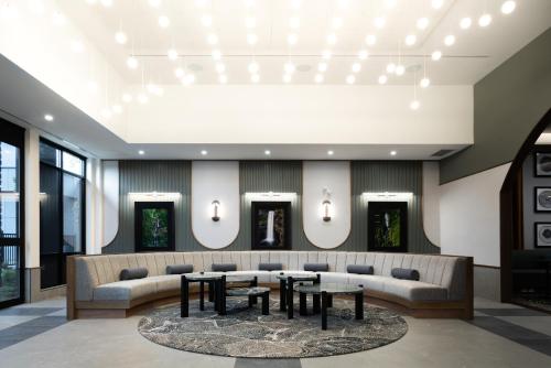 a lobby with a large couch and tables and chairs at Naturally Pacific Resort in Campbell River