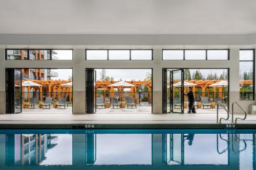 a person standing next to a swimming pool at Naturally Pacific Resort in Campbell River