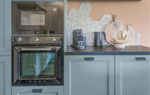 a kitchen with a stove and a microwave at Looshof in Helchteren