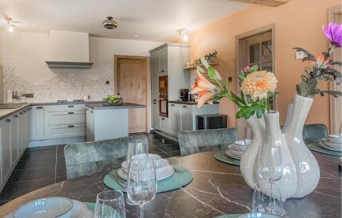a kitchen and dining room with a table with flowers in a vase at Looshof in Helchteren