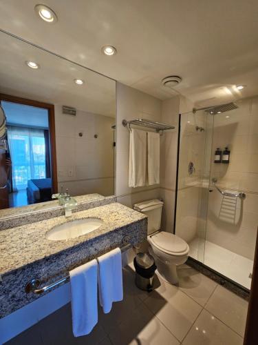 a bathroom with a sink and a toilet and a shower at Barra First Residence in Rio de Janeiro