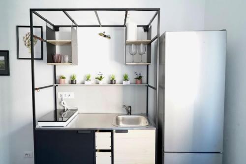 una cocina con fregadero y refrigerador en Molinari House Modena Smeraldino, en Módena