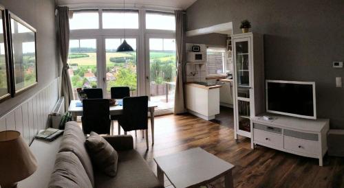 a living room with a couch and a table at Modern ausgestattetes Ferienhaus mit möblierter Südhang-Terrasse im Altenautal in Husen