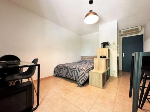 une chambre avec un lit, une table et un bureau dans l'établissement Studio appart'hôtel meublé et climatisé, à Avignon