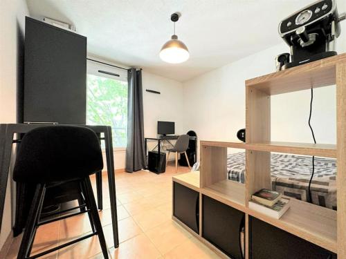 une pièce avec un bureau sur lequel est posée une caméra dans l'établissement Studio appart'hôtel meublé et climatisé, à Avignon