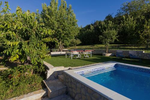 a swimming pool in a yard with a table and a picnic table at Family Little Paradise in Ružić