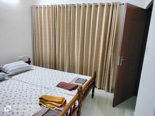 a bedroom with a bed and a large curtain at Ajith's Inn in Kottayam