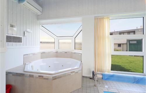 a large tub in a bathroom with a large window at Strandblick 11 in Schönhagen