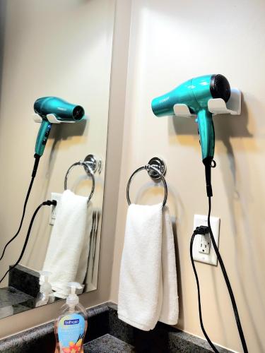 a blow dryer is plugged into a bathroom mirror at Spacious 2BR Near HWY 1, Heritage Park , Cultus Lake & Fishing! in Chilliwack