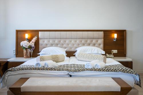 a large white bed with pillows on it in a room at Hotel Adrović in Sveti Stefan