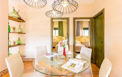 a dining room with a glass table and white chairs at Stunning Home In Ubrique With Kitchen in Ubrique