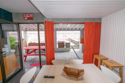 a room with a table and chairs and a room with a patio at Atlantic São Paulo - Nature in the city in Ponta Delgada