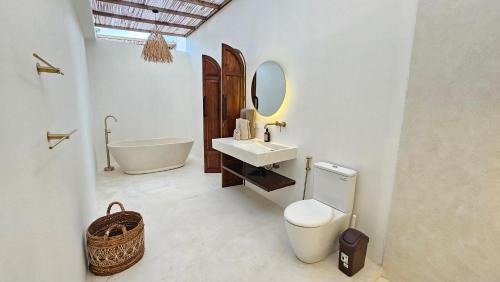 Un baño con bañera, inodoro y lavabo. en La Bianca Studio Apartment, en Dalung