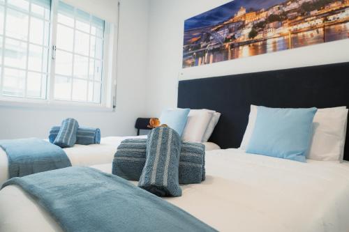 a bedroom with two beds and a painting on the wall at Douro Garden & Rooftop Home in Vila Nova de Gaia