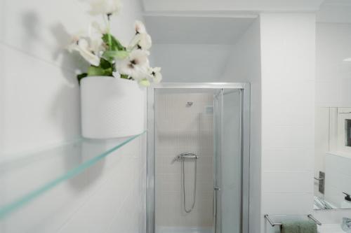 a bathroom with a shower with a vase of flowers at Douro Garden & Rooftop Home in Vila Nova de Gaia
