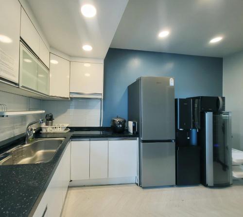 a kitchen with a refrigerator and a sink at Penatess Pool Villa in Chungju
