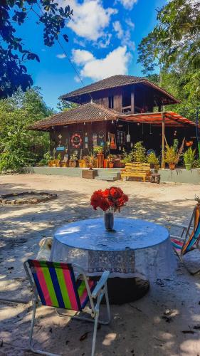 a table with a chair and a vase of flowers at Floresta Zen - Pousada Xamanica in Manaus