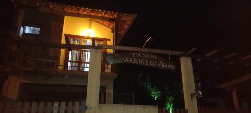 a sign in front of a building at night at Pousada Vertente das Águas in Lumiar