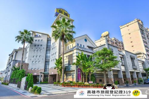 a building with palm trees in front of it at Purple Garden Motel in Kaohsiung