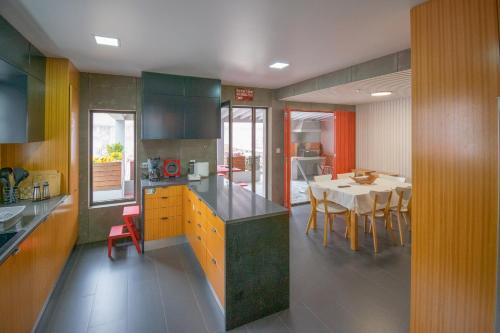 a kitchen with a table and a dining room at Atlantic São Paulo - Nature in the city in Ponta Delgada
