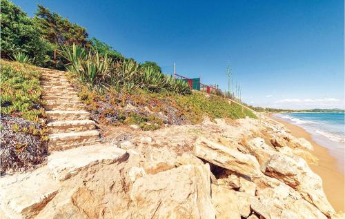 a rocky beach with stairs leading to the ocean at Gorgeous Home In Menfi Ag With Wifi in Porto Palo
