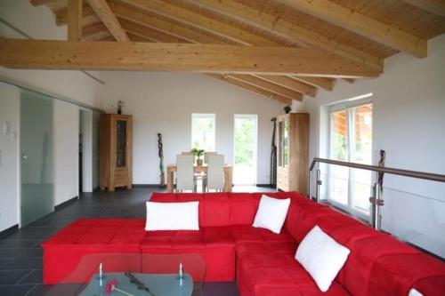 a red couch in the middle of a living room at Moderne Luxusvilla in Naturlage am Miltenberg, modernes Interieur, Profiküche in Miltenberg