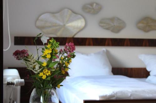 a vase of flowers on a table next to a bed at Ferienhaus für 6 Personen ca 126 m in Alsbach, Rhein Mittelrheintal in Alsbach