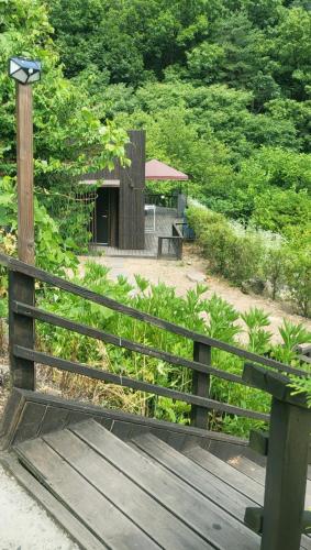 a wooden bench with a light on top of it at Penatess Pool Villa in Chungju