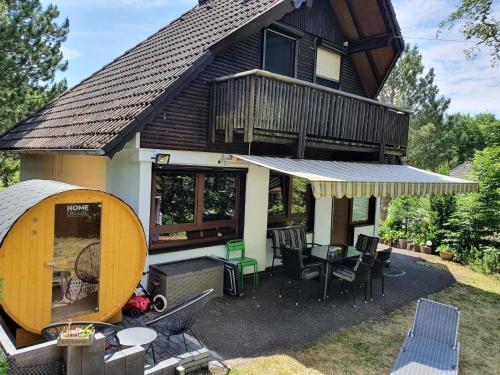 a large house with a deck and a table and chairs at Familienfreundliches Ferienhaus in Frielendorf in Frielendorf