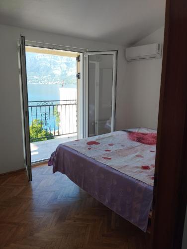 a bedroom with a bed and a view of the ocean at Amarillys in Donji Morinj