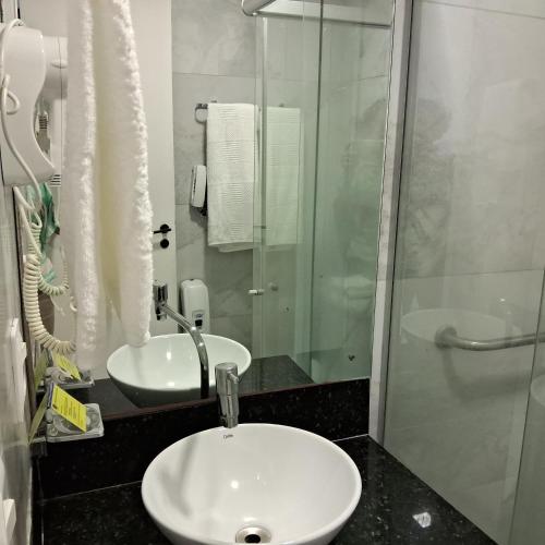 a bathroom with a sink and a glass shower at hotel tambau flat particular 605 in João Pessoa