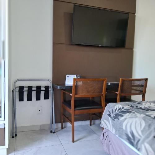 a bedroom with a desk and two chairs and a tv at hotel tambau flat particular 605 in João Pessoa