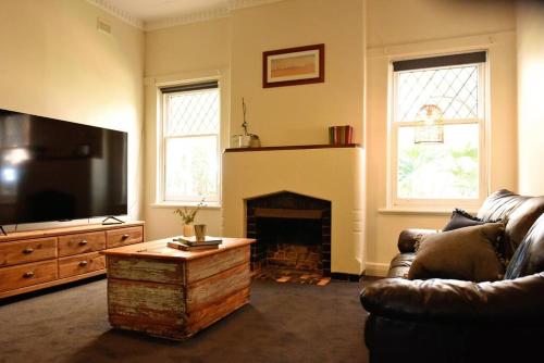 a living room with a couch and a fireplace at The Jetty House - Lake Bonney Riverland in Barmera