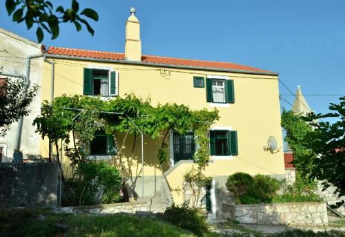 a yellow house with a tower at Insel Cres, Stivan, liebevoll restauriertes Dorfhaus über der Adriabucht Merascica in Štivan