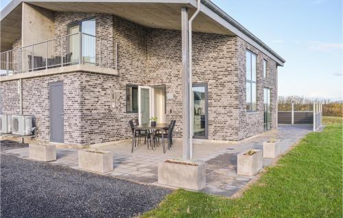 a brick house with a table on a patio at Holiday Home Ringkøbing 3 in Søndervig
