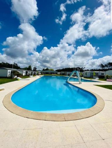 a large swimming pool with a blue sky in the background at Casa da Cristina 5A in Burinhosa